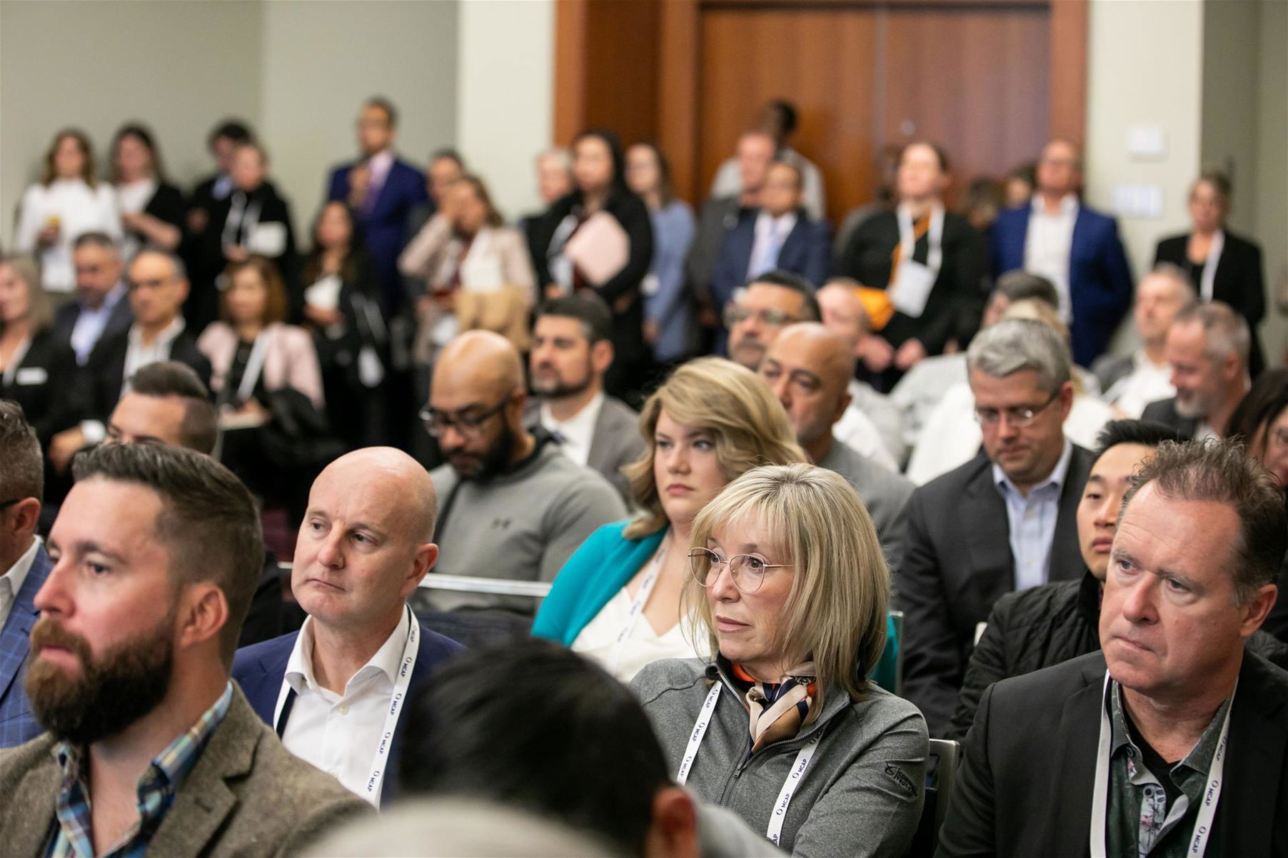 Group full of men and women listening to a presenter